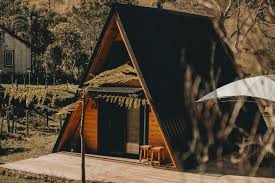 Chalé A-frame em madeira com varanda ao entardecer