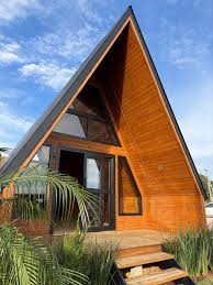 Chalé A-frame moderno com fachada em madeira e escada de acesso